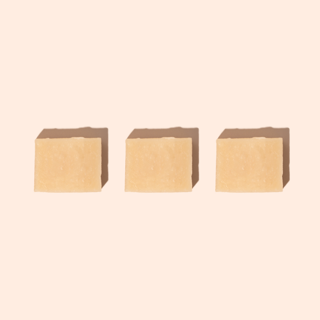 Trois savons beige clair disposés en ligne sur fond beige, formulés avec du lait de chèvre et de la sève de bouleau pour une peau renouvelée et apaisée.